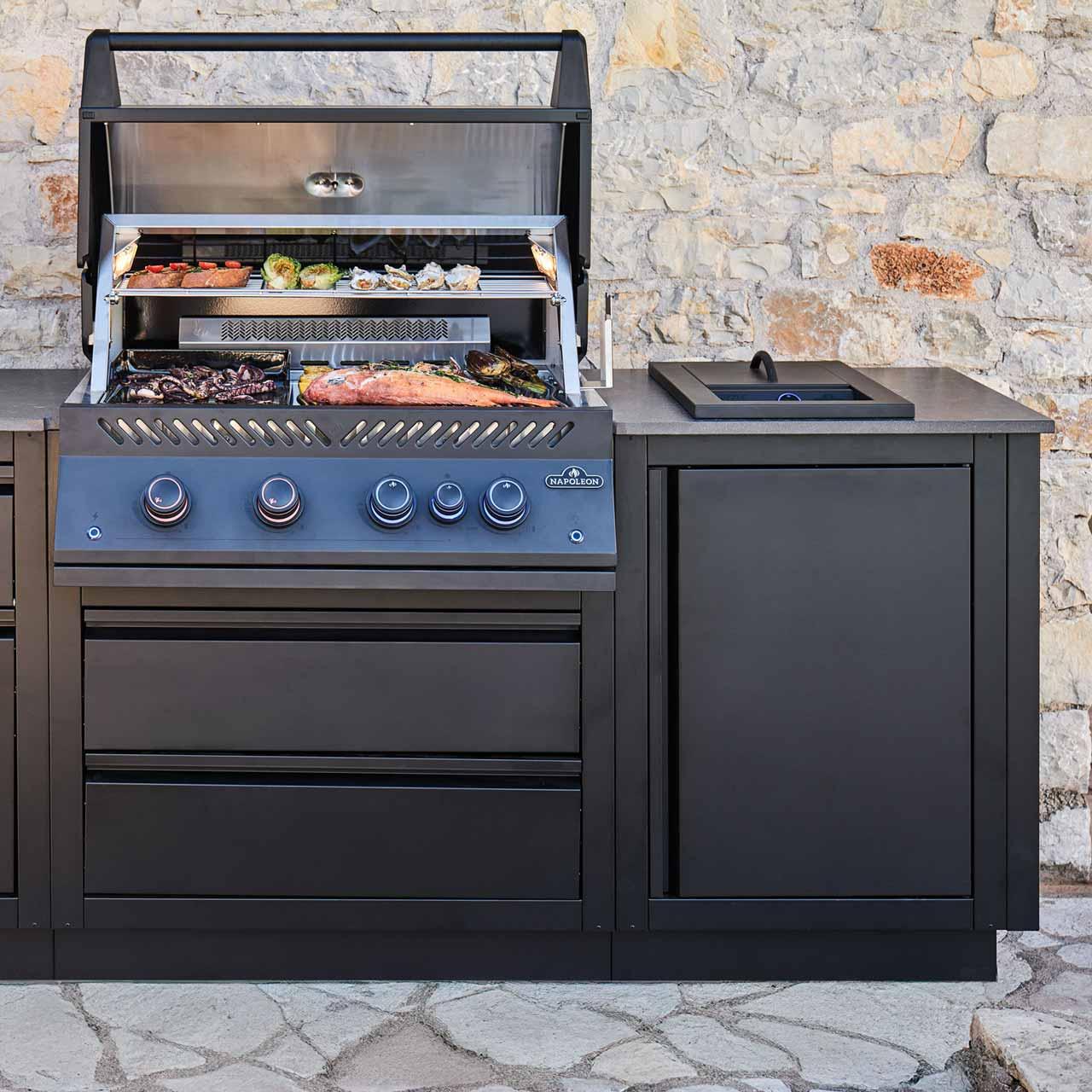 Outdoorküche Napoleon Oasis Compact 106 BIG32 Mattschwarz, mit Heckbrenner, Sizzle Zone, Drehspieß & Abdeckhaube
