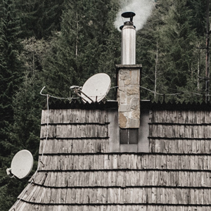 sanierter Schornstein auf Holzschindeldach
